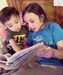 Alayna reading to brother
